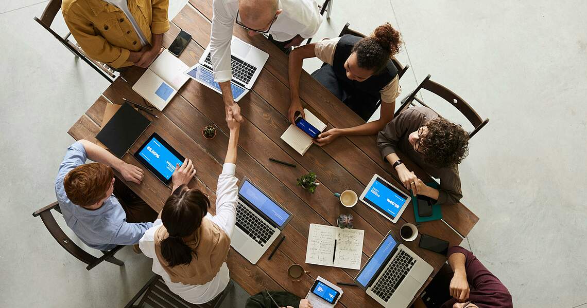 Menschen arbeiten an einem Tisch zusammen