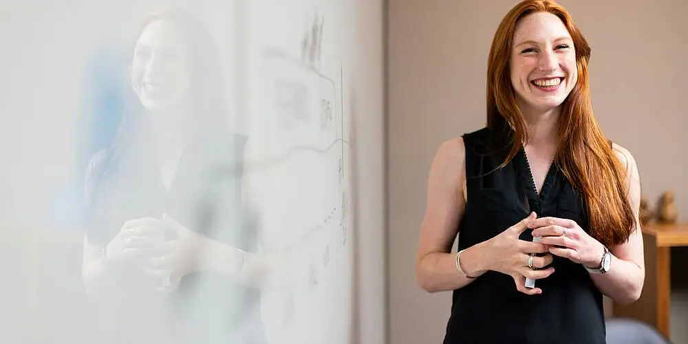 Frau steht vor Whiteboard